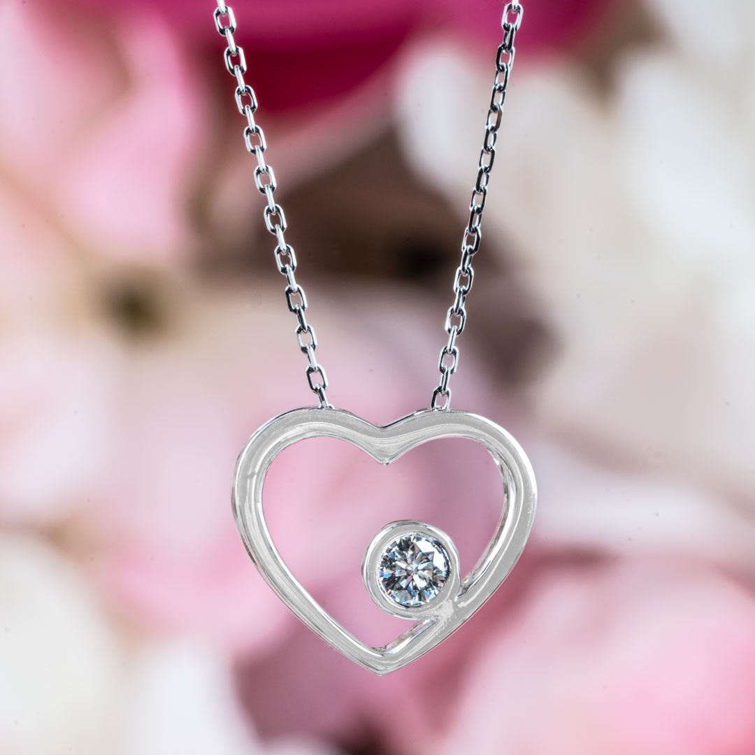 White gold heart station necklace set with a round diamond.