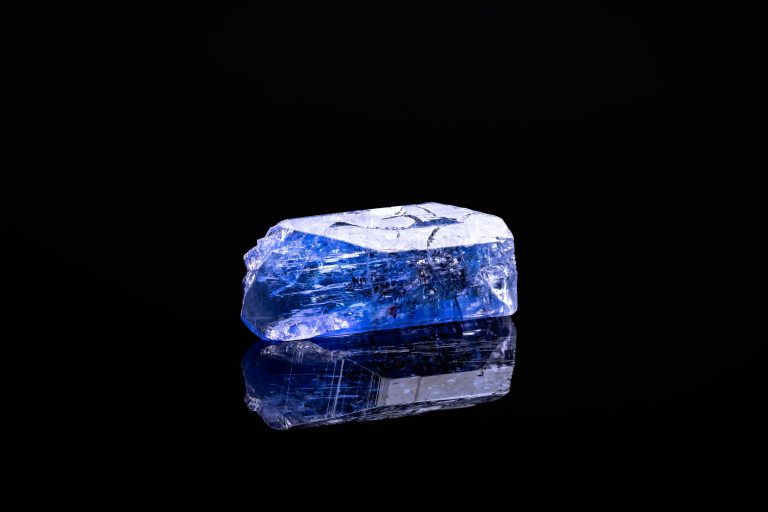 rough tanzanite specimen on a black background